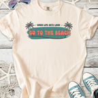Beige graphic t-shirt with 'Go to the Beach' print and palm tree design, perfect for summer outings.