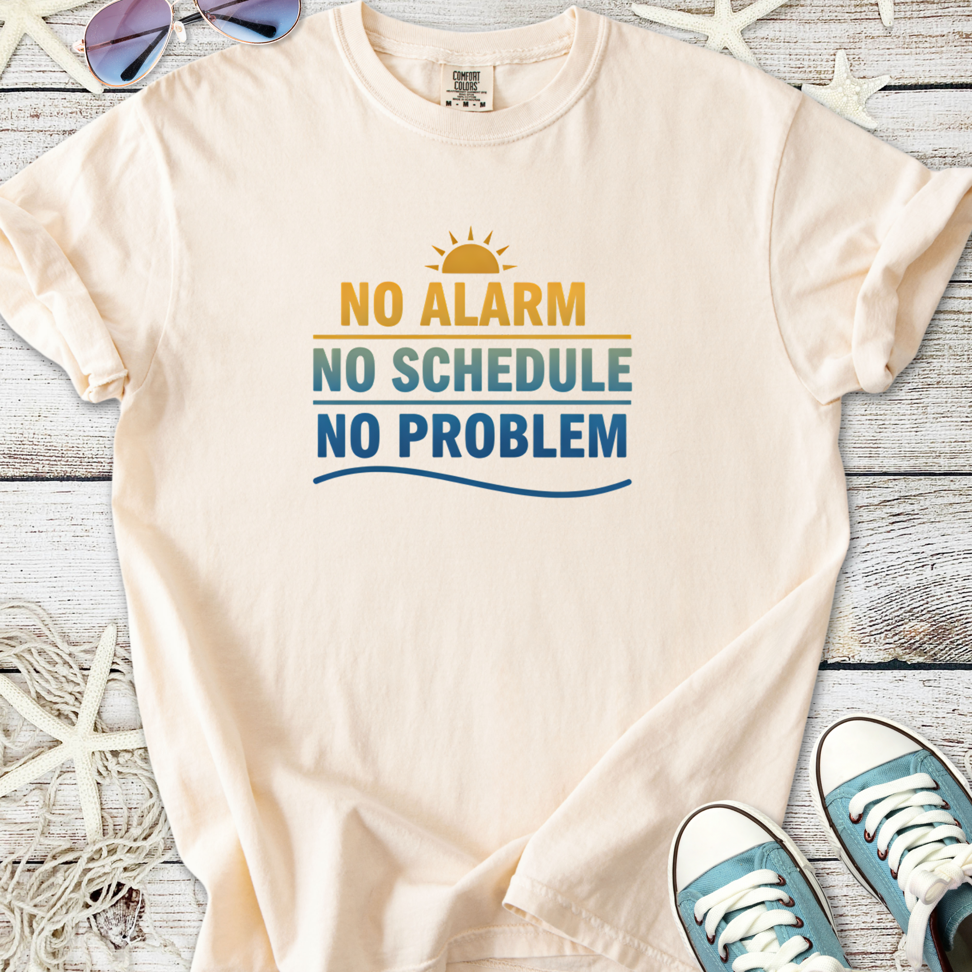 Cream cotton t-shirt with fun beachy print: 'No Alarm, No Schedule, No Problem' for casual summer wear.
