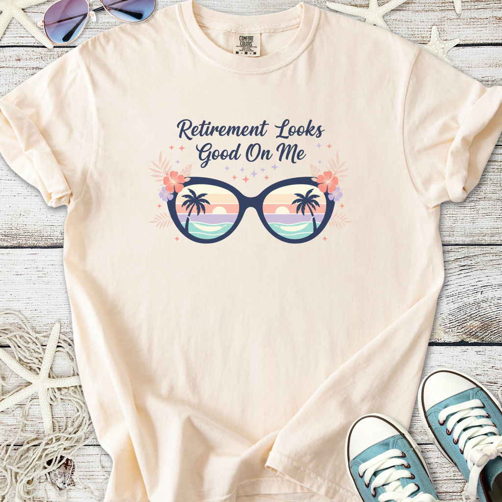 Light beige t-shirt with 'Retirement Looks Good On Me' graphic featuring sunglasses and tropical design.