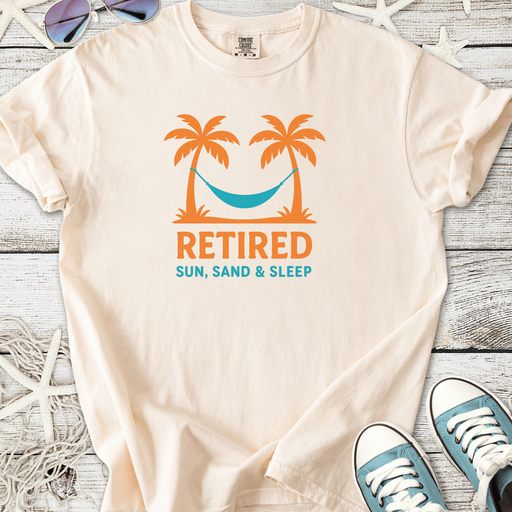 Cream retiree t-shirt with palm trees and hammock graphic, featuring 'Retired Sun, Sand & Sleep' text.