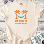 Cream retiree t-shirt with palm trees and hammock graphic, featuring 'Retired Sun, Sand & Sleep' text.
