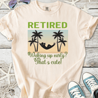 Cream retirement t-shirt with palm tree graphics and humorous text about waking up early.