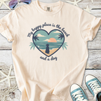Cream cotton t-shirt with beach-themed graphic saying 'My happy place is the beach and a dog'.