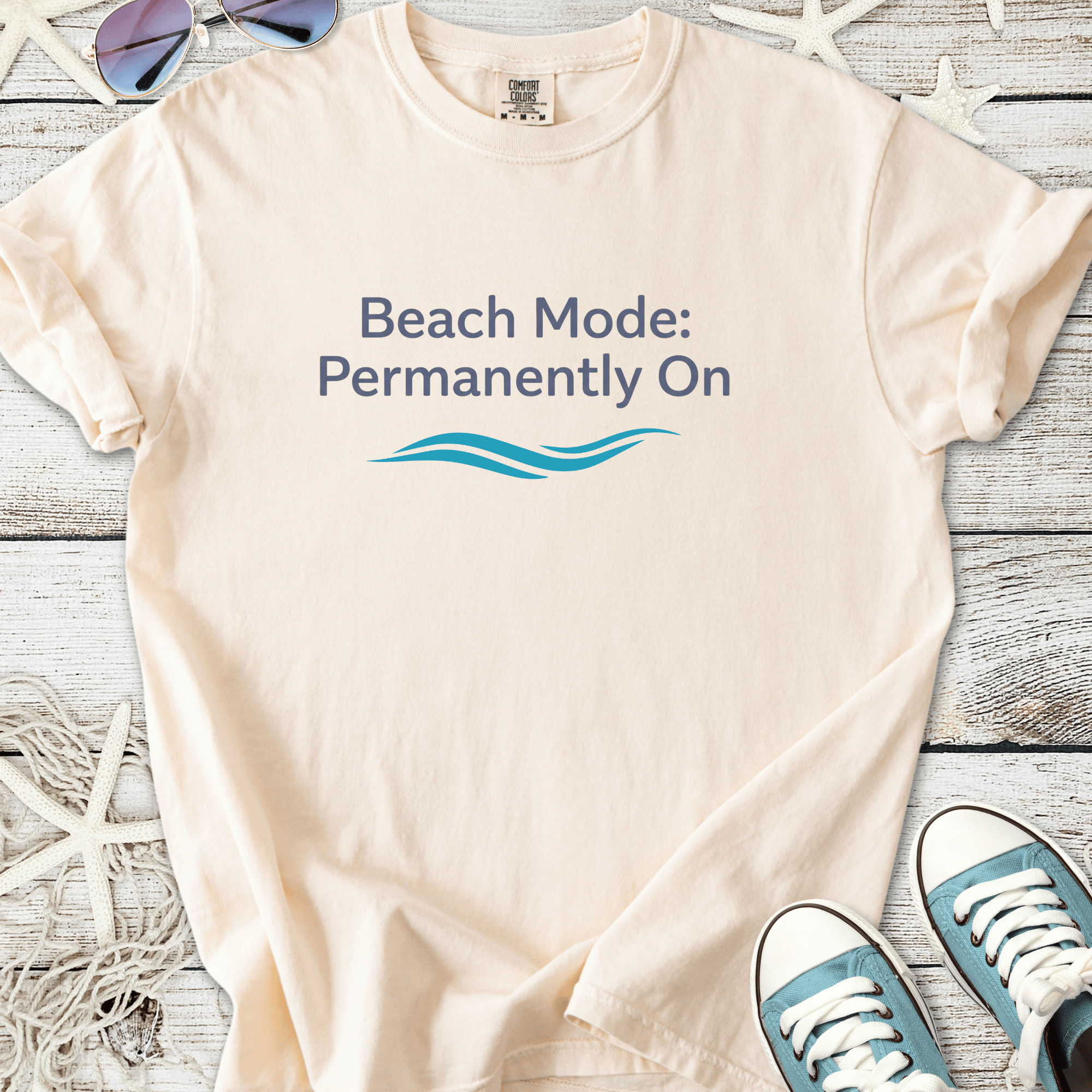 Cream cotton t-shirt with 'Beach Mode: Permanently On' print and wave design, perfect for summer wear.