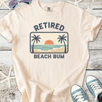 Light beige t-shirt with 'Retired Beach Bum' graphic, featuring a sunset and palm trees.