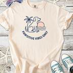 Light peach t-shirt featuring a dog, sunset, and 'Pawsitive Vibes Only' design, perfect for dog lovers.