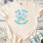 Light beige t-shirt with 'Sun, Salt, Sandy Paws' graphic, perfect for beach lovers and pet enthusiasts.