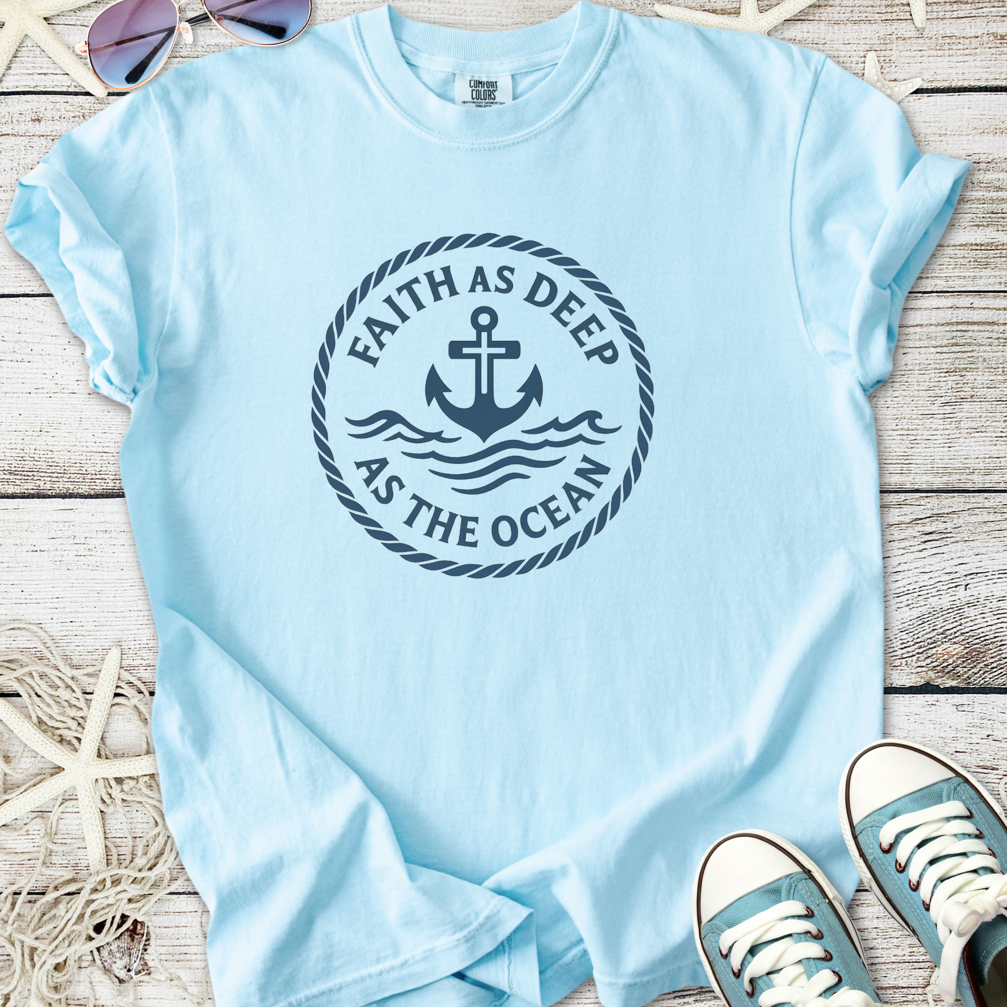 Light blue t-shirt with anchor design and 'Faith as Deep as the Ocean' text, made from soft cotton.