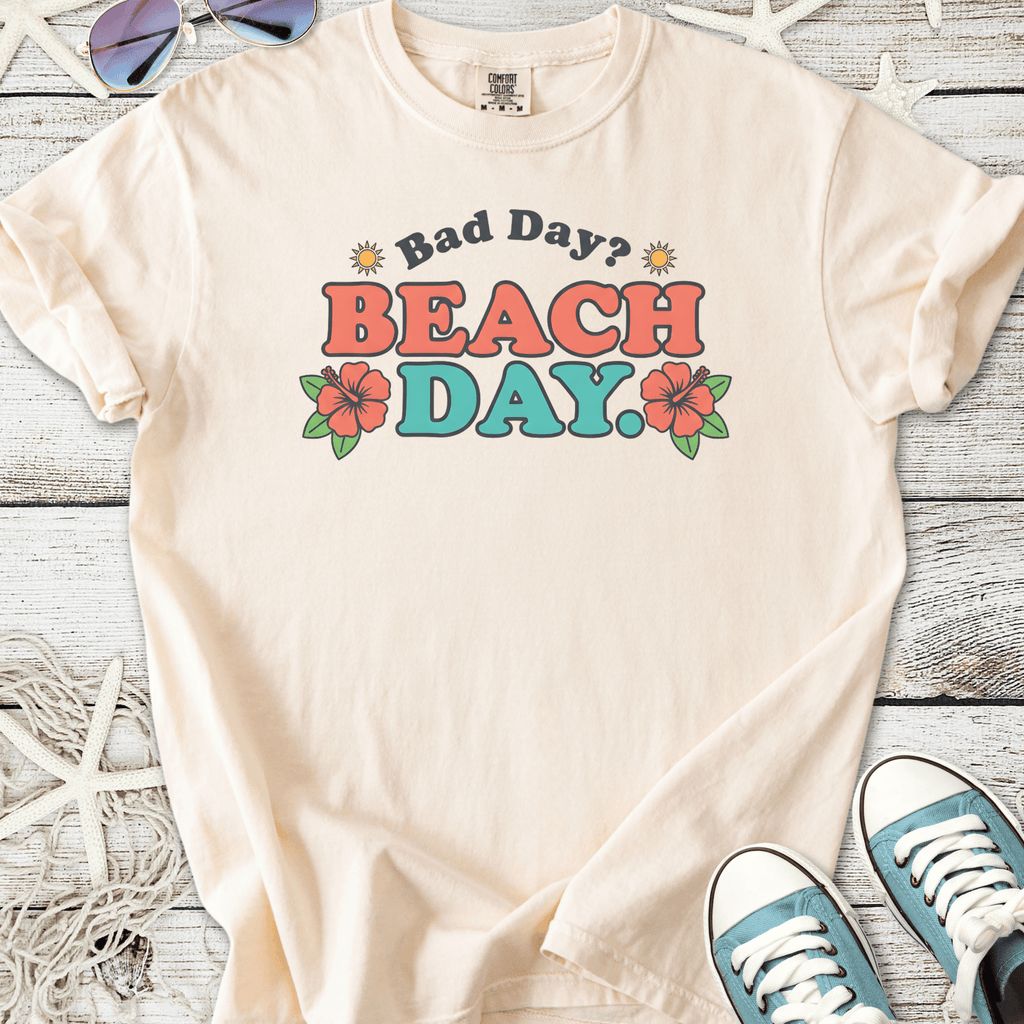 Cream cotton t-shirt with 'Bad Day? BEACH DAY.' graphic and floral designs.