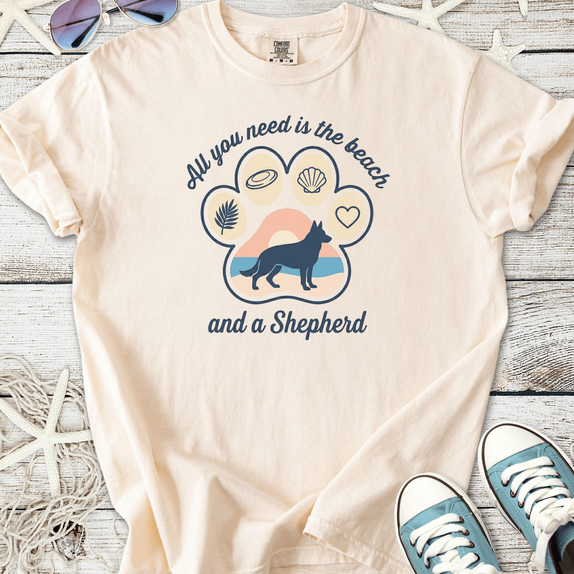 Light beige t-shirt with 'All you need is the beach and a Shepherd' graphic design. Made from soft cotton.