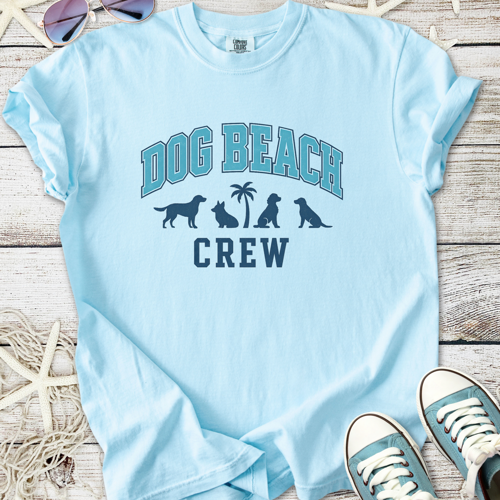 Light blue t-shirt with 'Dog Beach Crew' graphic and dog silhouettes, perfect for beach outings.