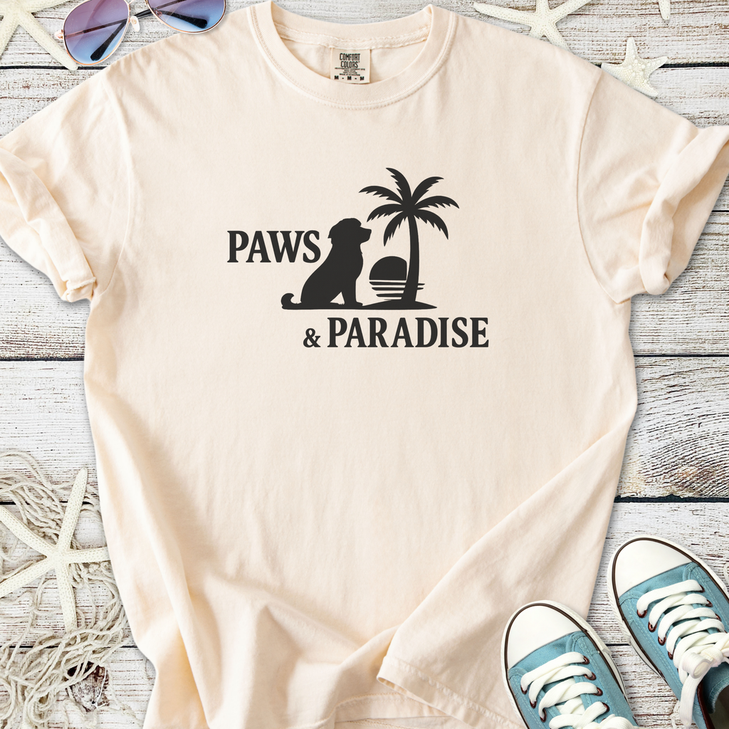 Cream cotton t-shirt featuring 'Paws & Paradise' design with a dog and palm tree graphic.