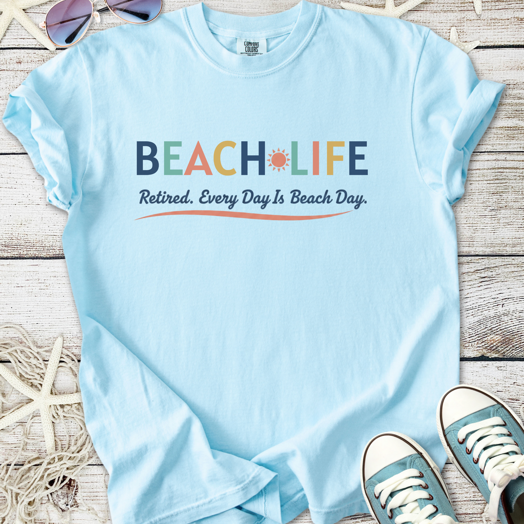 Light blue t-shirt with 'BEACH LIFE' print, perfect for retirees, casual wear for beach lovers.