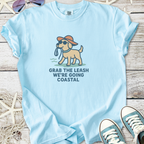 Light blue unisex t-shirt featuring a dog with sunglasses and a hat, text: 'Grab the leash, we’re going coastal'.