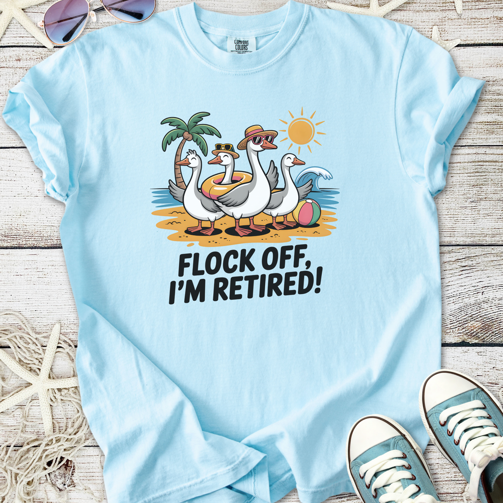 Light blue cotton t-shirt featuring cartoon ducks on a beach, text 'Flock Off, I'm Retired!'