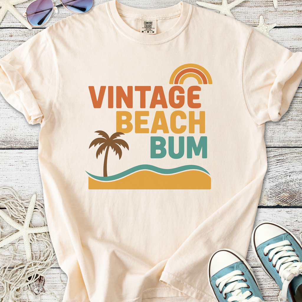 Cream vintage t-shirt with 'Vintage Beach Bum' graphic, featuring a palm tree and waves. Perfect for beach lovers.