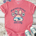 Pink graphic tee with beach-themed paw print design, featuring the text 'All you need is the beach and a dog'.
