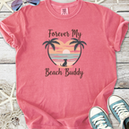 Pink graphic t-shirt featuring 'Forever My Beach Buddy' with palm trees and sunset design.