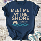 Navy blue t-shirt with 'Meet Me at the Shore' design, featuring a cross, waves, and biblical verse Acts 22:16.