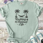 Mint green t-shirt featuring 'Rocking the Retired Life' design with palm trees and a hammock.