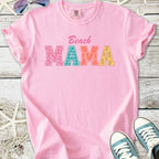 Pink cotton t-shirt with 'Beach MAMA' graphic in colorful letters, perfect for summer outings.